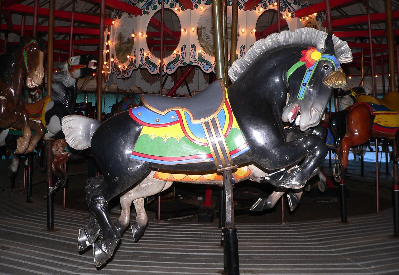 A carved black horse with a painted saddle on the Ross Park Carousel, one of Binghamton's George F. Johnson carousels.